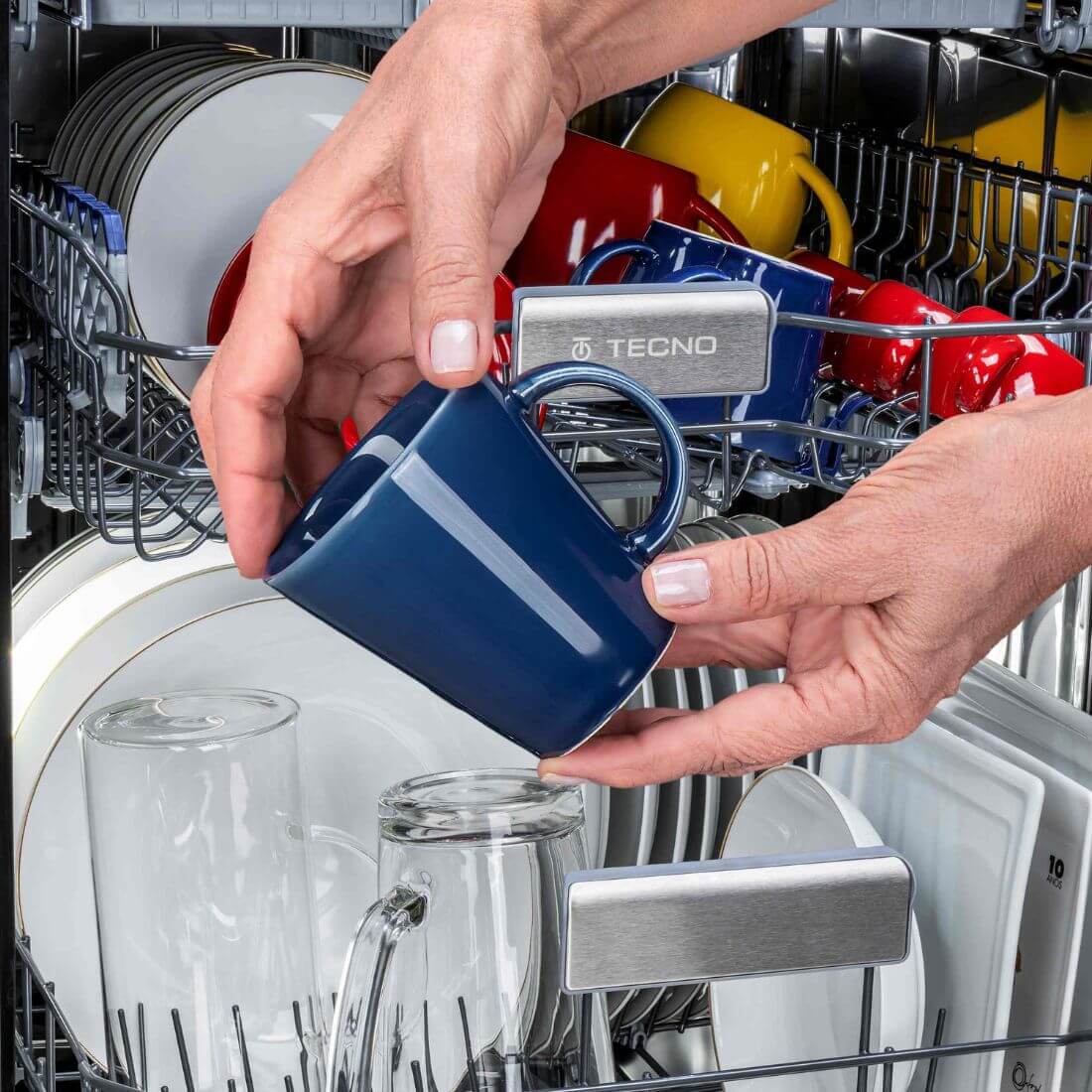 Lava-Louças Tecno de Revestir 16 serviços inox 60cm mostrando canecas e pratos sendo carregados no interior espaçoso