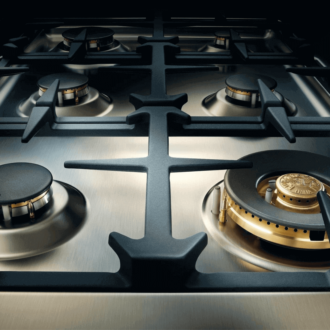 Close-up do fogão Bertazzoni com 6 queimadores a gás e trempes robustas em ferro fundido.