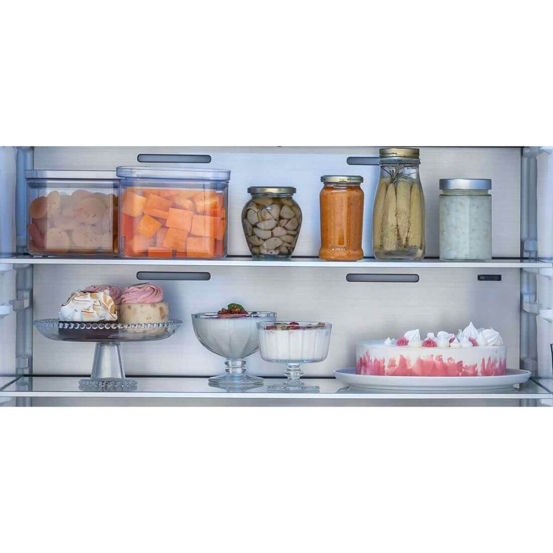 Interior do refrigerador Bertazzoni com frutas e sobremesas em potes e recipientes organizados.