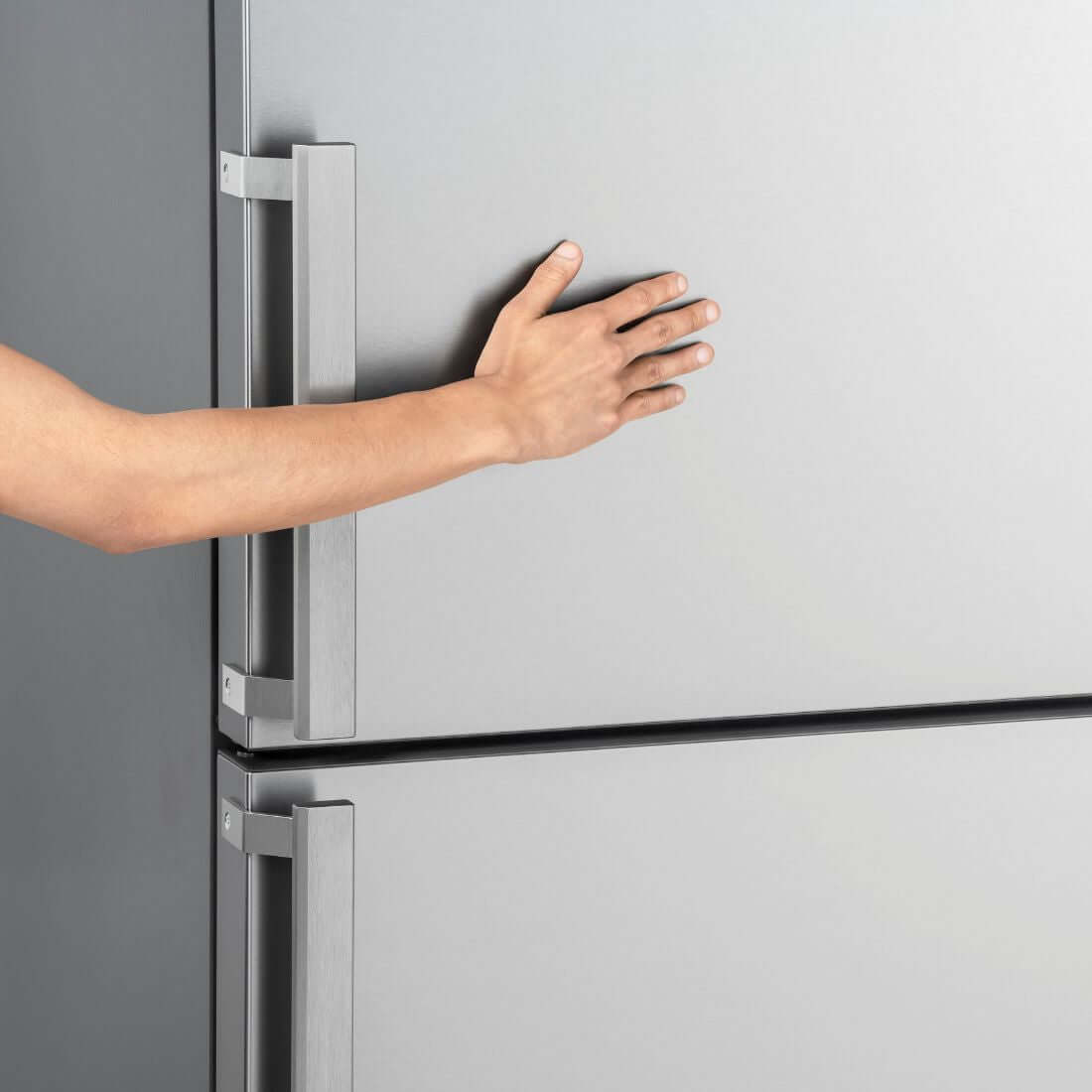 Mão abrindo a porta do Refrigerador Bertazzoni Professional Bottom Freezer com design em aço inox.